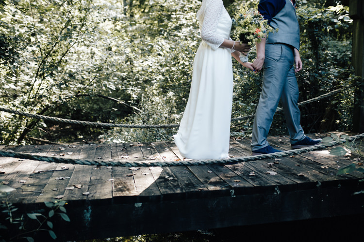 Outdoor First Look Bride Handmade Lace Floral Belt Bridal Gown Bouquet Orange Carnations Thistle Gypsophila Groom Grey Vest Pants Navy Blue Shirt Buttonhole Orange Florals Succulent Adventure Inspired Woodland Wedding North Carolina http://www.amandasuttonphotography.com/