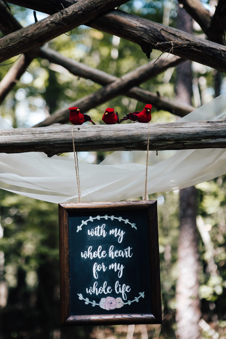 Outdoor Ceremony Decorated Wooden Arbour White Organza Red Birds DIY Quote Sign Blackboard Adventure Inspired Woodland Wedding North Carolina http://www.amandasuttonphotography.com/