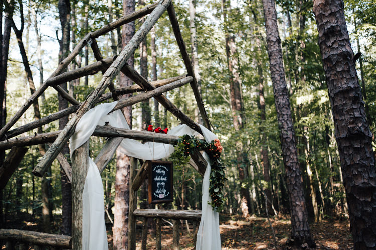 Outdoor Ceremony Decorated Wooden Arbour White Organza Orange Florals Greenery Red Birds DIY Quote Sign Blackboard Adventure Inspired Woodland Wedding North Carolina http://www.amandasuttonphotography.com/