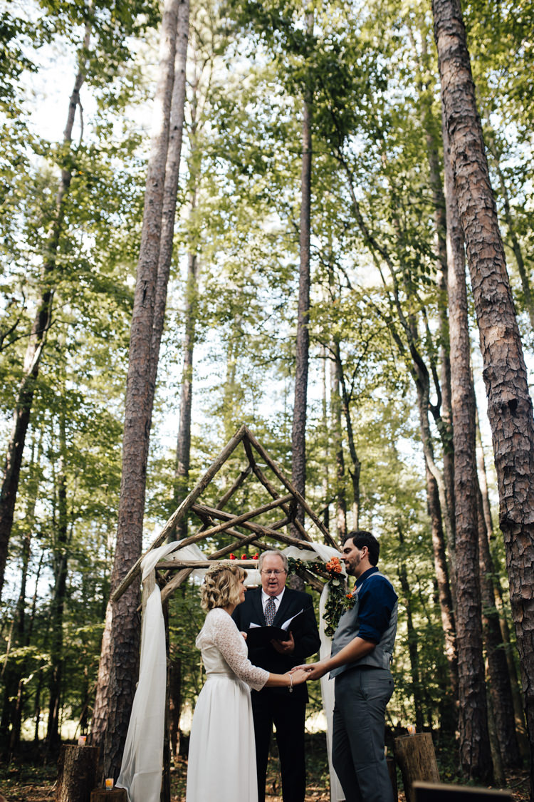 Outdoor Ceremony Bride Handmade Lace Bridal Gown Groom Grey Vest Pants Navy Blue Shirt Orange Tie Decorated Wooden Arbour Fresh Florals Celebrant Adventure Inspired Woodland Wedding North Carolina http://www.amandasuttonphotography.com/
