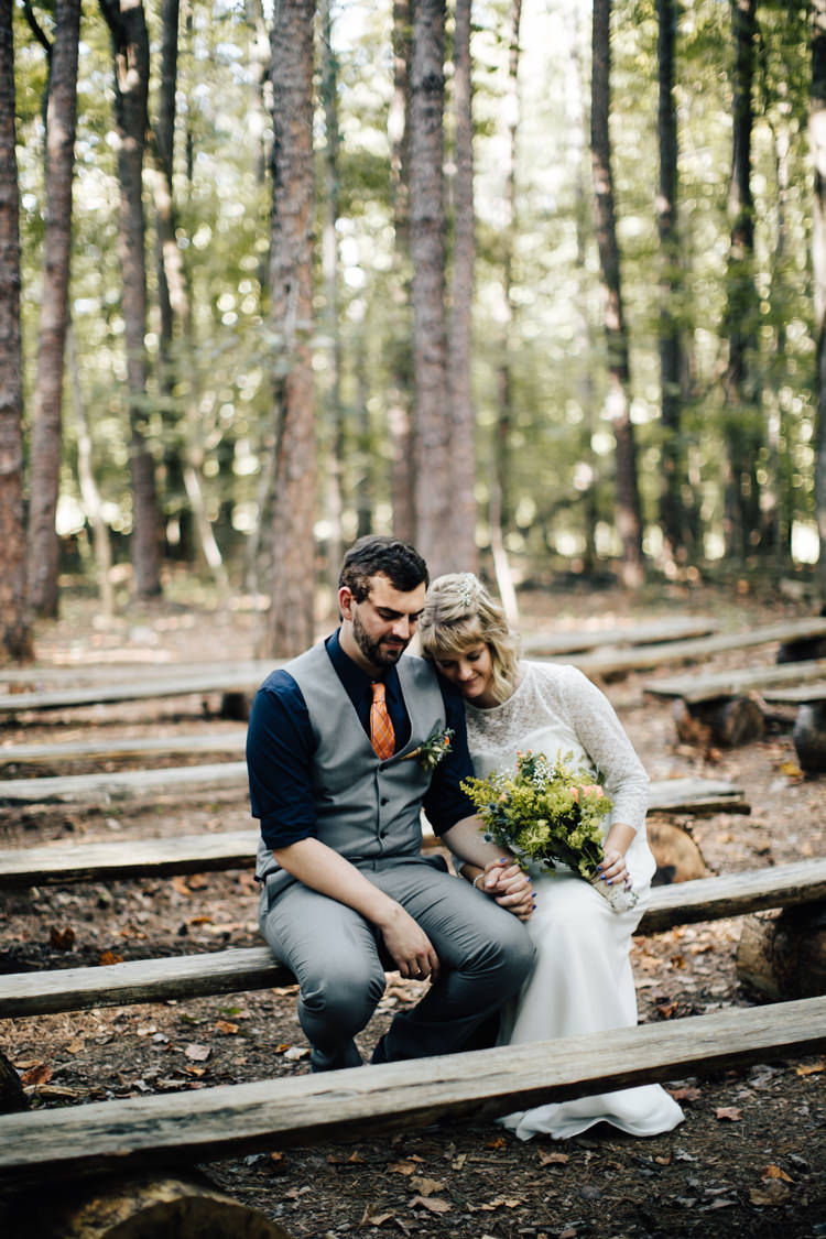 Outdoor Ceremony Location Bride Handmade Lace Bridal Gown Bouquet Groom Grey Vest Pants Navy Blue Shirt Orange Checkered Tie Wooden Bench Seating Adventure Inspired Woodland Wedding North Carolina http://www.amandasuttonphotography.com/