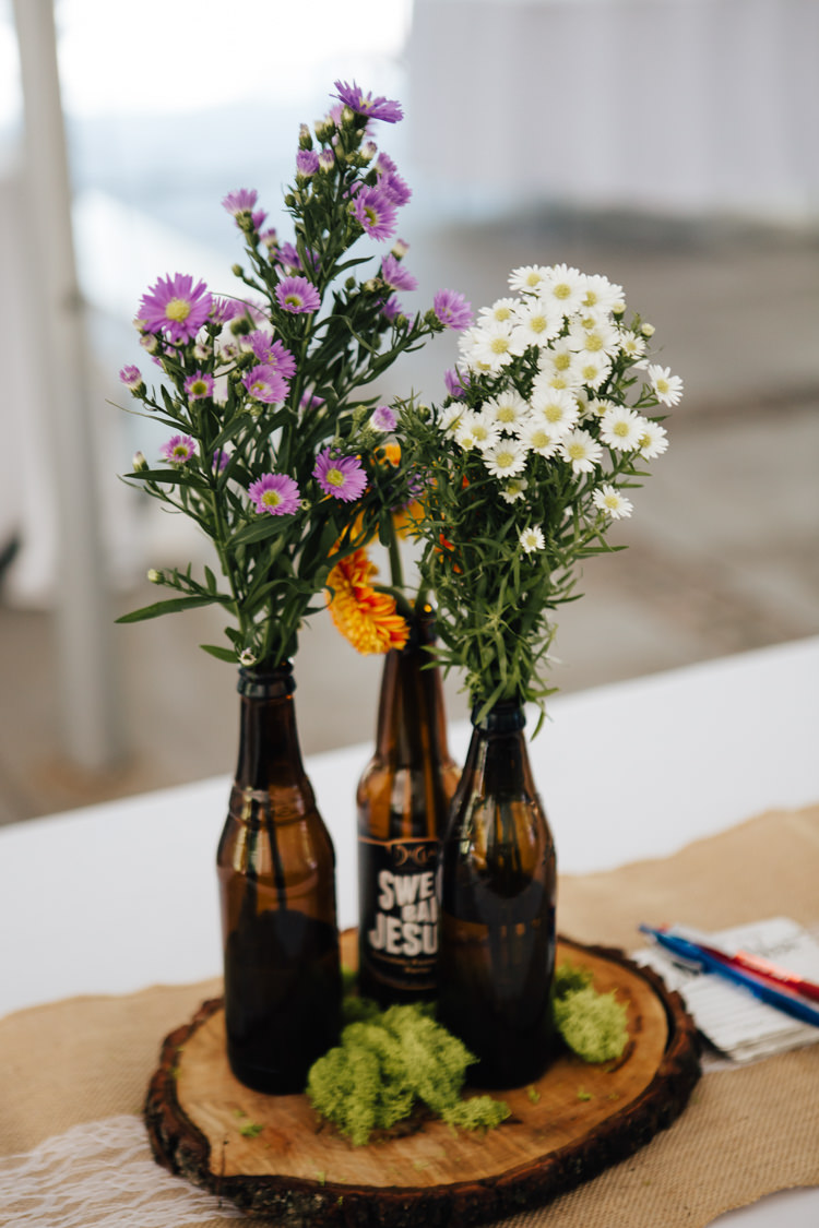 Reception Table Setting DIY Centrepieces Beer Bottles Fresh Purple White Florals Wood Slice Hessian Lace Table Runner Adventure Inspired Woodland Wedding North Carolina http://www.amandasuttonphotography.com/