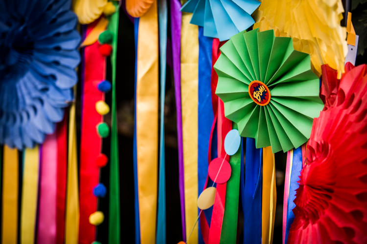 Ribbon Backdrop Pinwheels Lanterns Bunting Outdoor Rainbow Colourful Vintage Comic Book Wedding Ideas http://www.hayleypettitphotography.com/