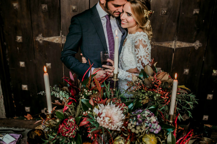 Bride Lace Backless Bridal Gown Intricate Autumn Leaves Headpiece Groom Charcoal Suit Purple Patterned Tie Rustic Reception Table Setting Fresh Flowers Gold Candlesticks From Dawn To Eternity Autumnal Wedding Ideas http://www.nataliaibarra.com