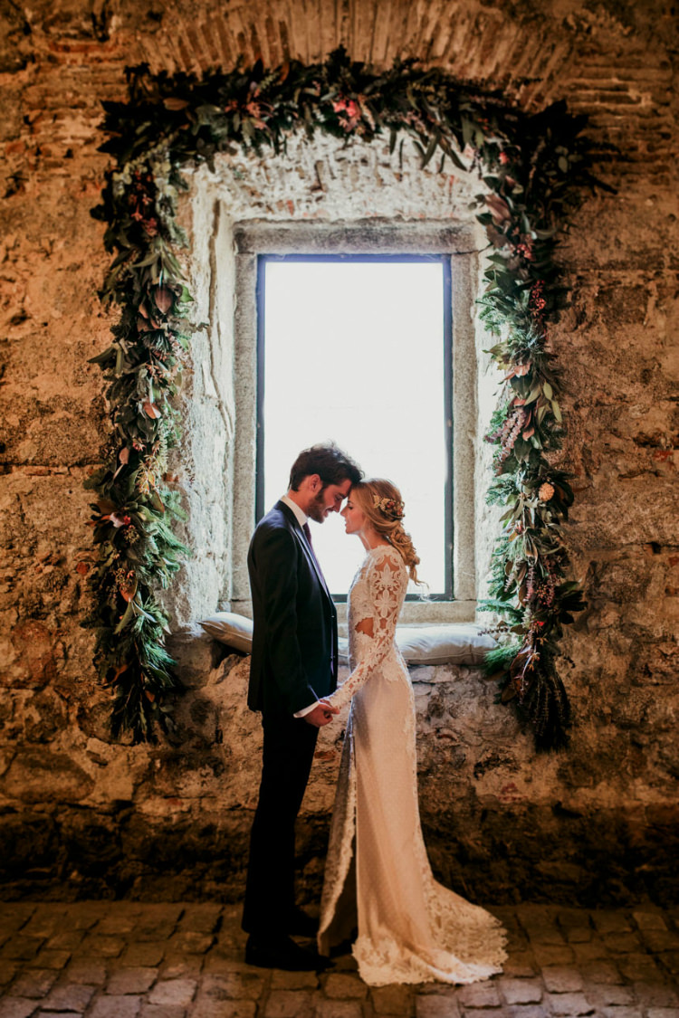 Bride Lace Backless Bridal Gown Intricate Autumn Leaves Headpiece Groom Charcoal Suit Purple Patterned Tie Window Florals Greenery From Dawn To Eternity Autumnal Wedding Ideas http://www.nataliaibarra.com