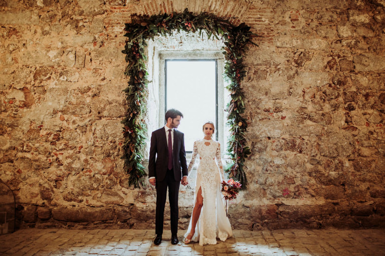 Bride Lace Backless Bridal Gown Intricate Autumn Leaves Headpiece Groom Charcoal Suit Purple Patterned Tie Window Florals Greenery From Dawn To Eternity Autumnal Wedding Ideas http://www.nataliaibarra.com