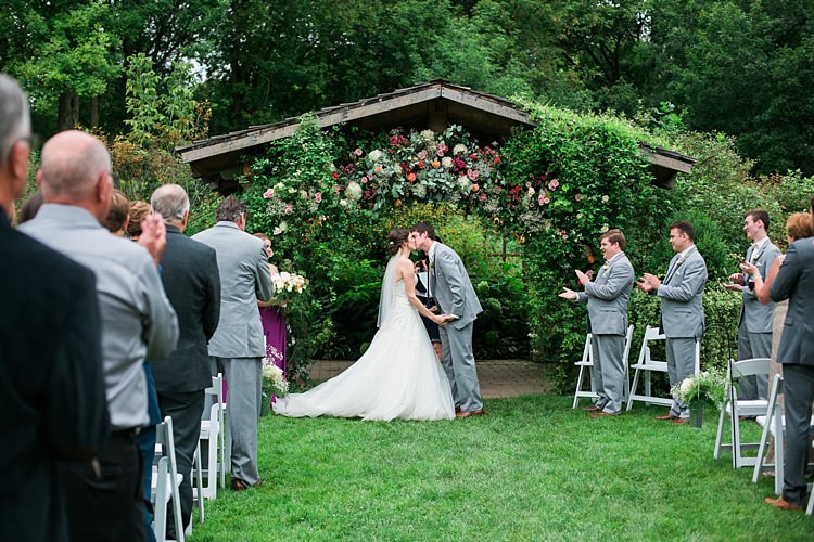 Outdoor Ceremony Bride Embellished Strapless Bridal Gown Veil Groom Light Grey Suit Guests Floral Arbour Flower Farm Outdoor Wedding Minnesota http://eileenkphoto.com/