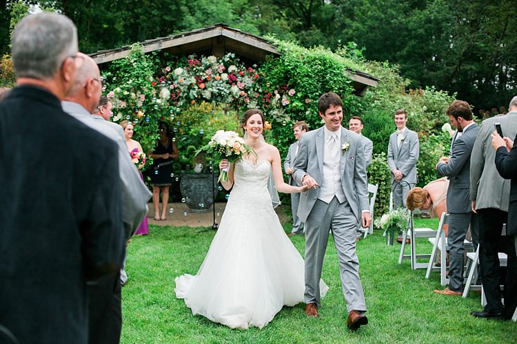 Outdoor Ceremony Bride Embellished Strapless Bridal Gown Bouquet Pale Pink White Roses Groom Light Grey Suit White Vest Tie Guests Floral Arbour Flower Farm Outdoor Wedding Minnesota http://eileenkphoto.com/