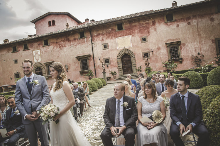 Outdoor Ceremony Bride Lace Tulle Stella York Bridal Gown Bouquet White Pink Roses Groom Light Blue Suit White Shirt Textured Blue Tie Guests Historic Pink Villa Romantic Intimate Tuscany Destination Wedding http://angelicabraccini.com/