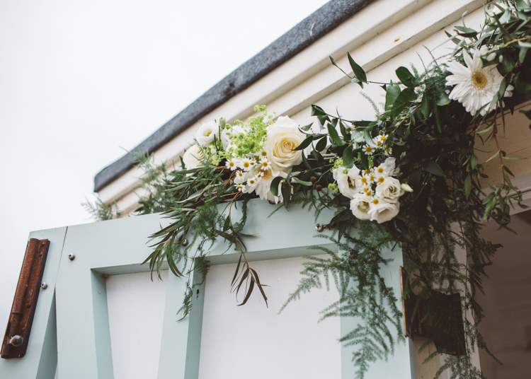 Arch Flowers Greenery Foliage White Blooms Backdrop Low Key Pastel Seaside Wedding http://holliecarlinphotography.com/