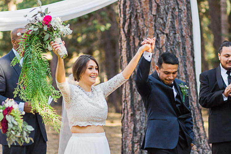 Outdoor Ceremony Bride Watters Separates Lace Top Tulle Skirt Veil Cascading Multicoloured Bouquet Groom Dark Blue Jacket Black Satin Lapel Black Pants Bowtie Celebrant DIY Whimsical Camp Wedding California http://www.landbphotography.org/