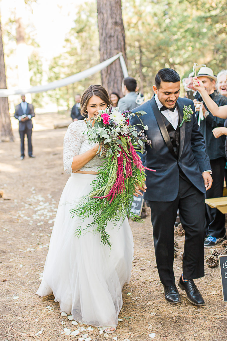 Outdoor Ceremony Bride Watters Separates Lace Top Tulle Skirt Cascading Multicoloured Bouquet Groom Dark Blue Jacket Black Satin Lapel Black Pants Vest Bowtie Floral Buttonhole Guests DIY Whimsical Camp Wedding California http://www.landbphotography.org/