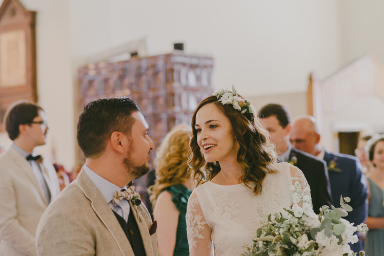 Church Ceremony Bride Two Piece Lace Bridal Gown Floral Hairpiece Bouquet White Florals Greenery Groom Light Blue Shirt Dark Grey Vest Sand Jacket Patterned Bowtie Natural Greenery Stylish Wedding Transylvania https://raresion.com/