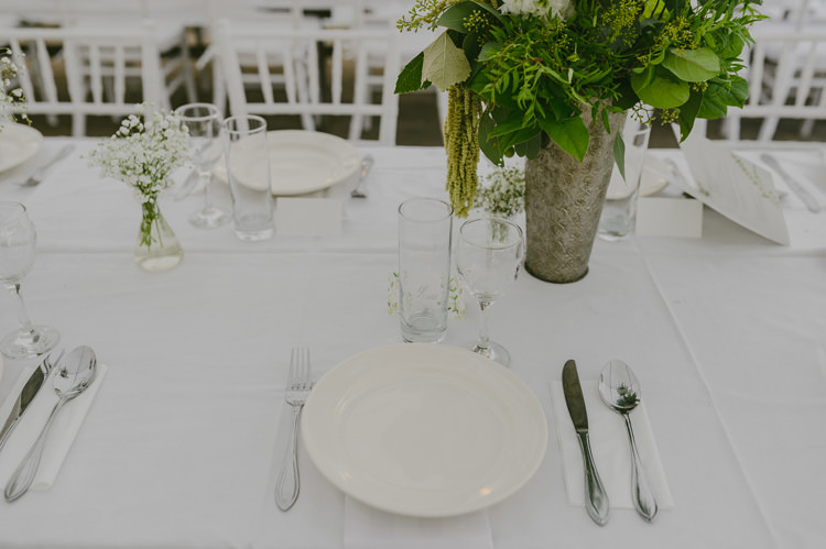 Reception Table Setting White Tablecloth Centrepiece Greenery Floral Fruit Arrangement Silver Vase Silver Cutlery Natural Greenery Stylish Wedding Transylvania https://raresion.com/