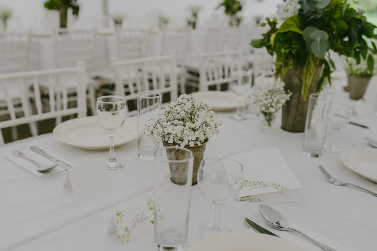 Reception Table Setting Potted White Florals White Chairs Silver Cutlery Centrepiece White Floral Greenery Arrangement Silver Vase Natural Greenery Stylish Wedding Transylvania https://raresion.com/
