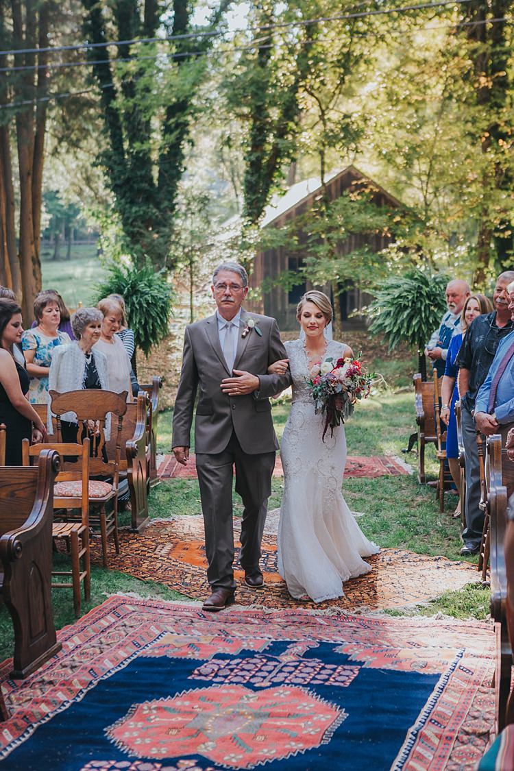 Outdoor Ceremony Bride V Neck Lace Embellished Bridal Gown Veil Multicoloured Bouquet Father Bright Rugs Guests Mismatched Wooden Chairs Bohemian & Whimsical Garden Wedding in North Carolina http://www.taylorparkerphotography.com/