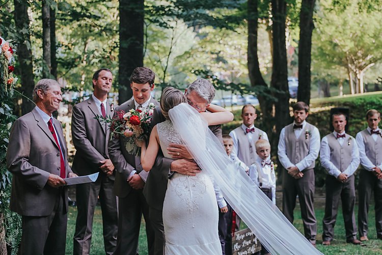 Outdoor Ceremony Bride Lace Embellished Gown Long Veil Father Groom Grey Suit Celebrant Groomsmen Floral Arch Bohemian & Whimsical Garden Wedding in North Carolina http://www.taylorparkerphotography.com/