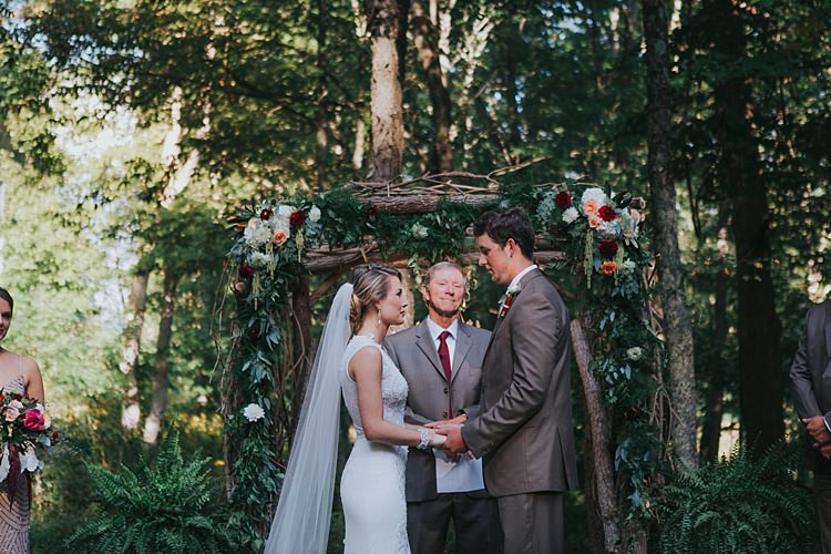 Outdoor Ceremony Floral Arch Bride V Neck Lace Embellished Gown Long Veil Groom Grey Suit White Shirt Floral Buttonhole Celebrant Bohemian & Whimsical Garden Wedding in North Carolina http://www.taylorparkerphotography.com/
