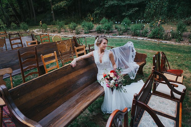 Bride V Neck Lace Embellished Bridal Gown Long Veil Multicoloured Bouquet Dahlia Garden Rose Florals Greenery Mismatched Wooden Chairs Pews Bohemian & Whimsical Garden Wedding in North Carolina http://www.taylorparkerphotography.com/