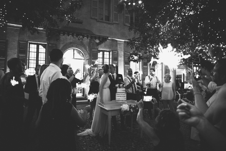 Reception Cake Cutting Bride V Neck Jenny Packham Embellished Bridal Gown Groom Tailored Black Suit Guests Fairy Lights Botanical Copper Greenery Lake Como Wedding http://margheritacalatiphotography.com/