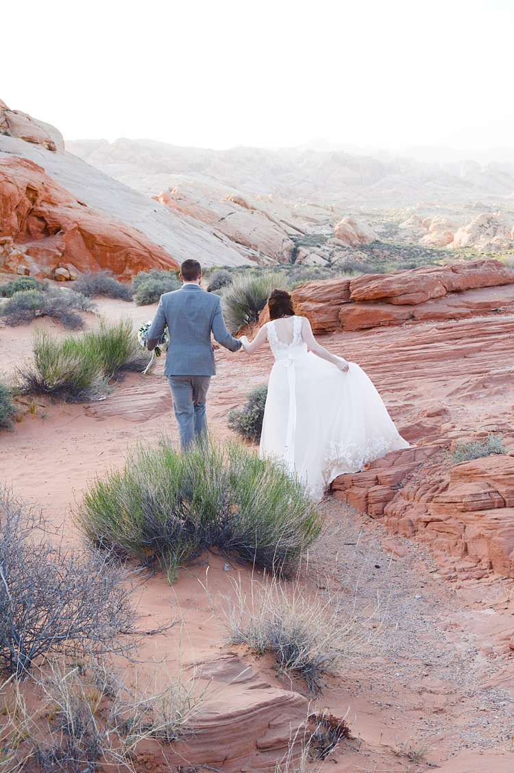 Bride Groom Climbing Windy Valley of Fire Wedding Nevada https://cactusandlaceweddings.com/