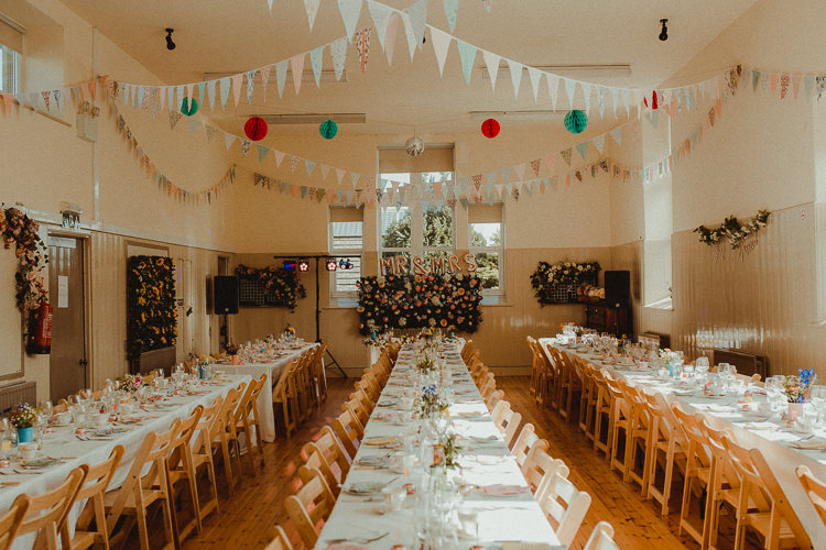 Village Hall Flower Wall Bunting Lanterns Long Tables Eclectic Kitsch Retro Fete Wedding http://www.belleartphotography.com/
