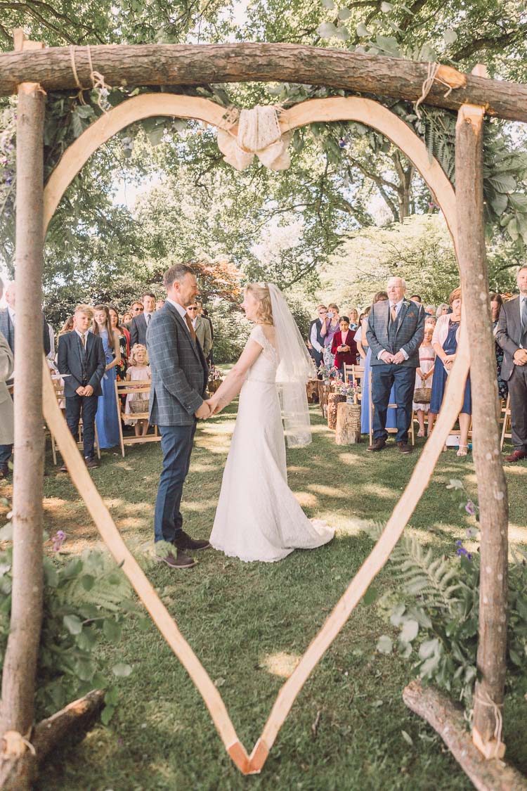 Ceremony Backdrop Wooden Heart Tree DIY Homemade Kate Walker Bride Dress Gown Moss Bros Tweed Groom Relaxed Outdoor Marquee Farm Wedding http://www.jenniferjanephotography.co.uk/
