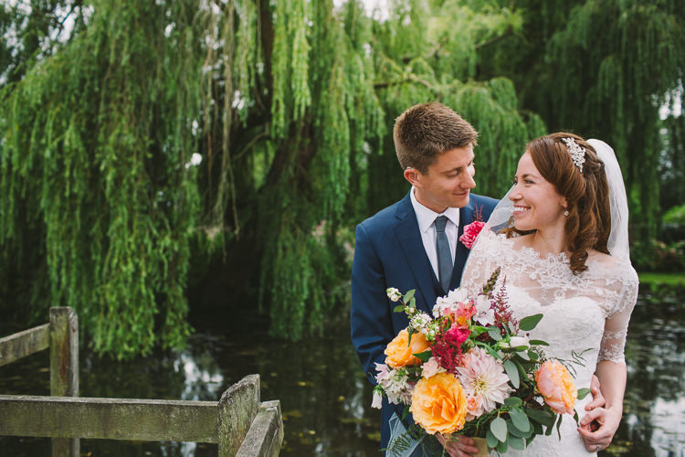 Bride Bridal Dress Gown Sweetheart Neckline Lace Jacket Diamante Belt Moss Bros Groom Navy Suit Three Piece Waistcoat Bouquet Dahlia Rose Berries Greenery Fairy Lights Vibrant Florals Summer Barn Wedding https://www.oliviajudah.co.uk/