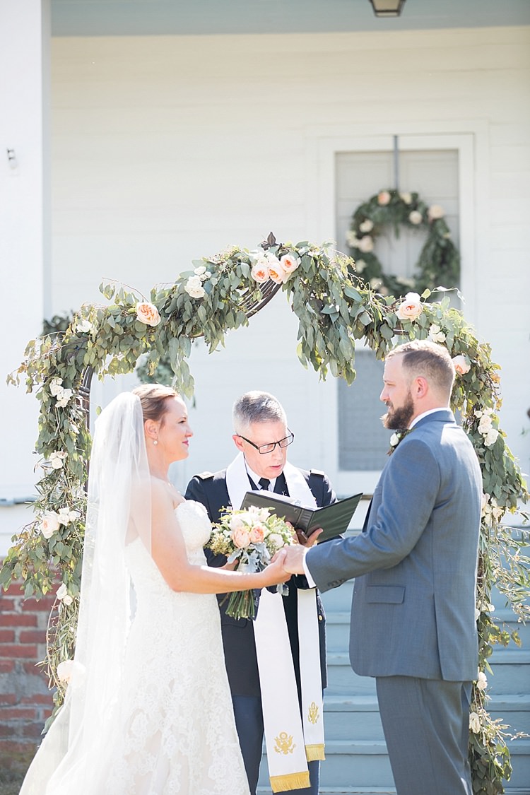 Groom Grey Suit Blue Tie Bride Long Veil Lace Dress Sweetheart Neckline Outdoor Ceremony Archway Greenery Intimate Farmhouse Wedding South Carolina https://jessicahuntphotography.com/