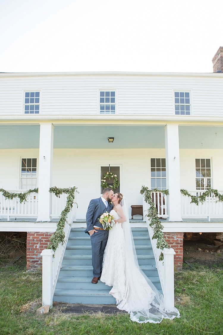 Groom Grey Suit Blue Tie Bride Long Veil Lace Dress Sweetheart Neckline Outdoor Ceremony Archway Greenery Intimate Farmhouse Wedding South Carolina https://jessicahuntphotography.com/