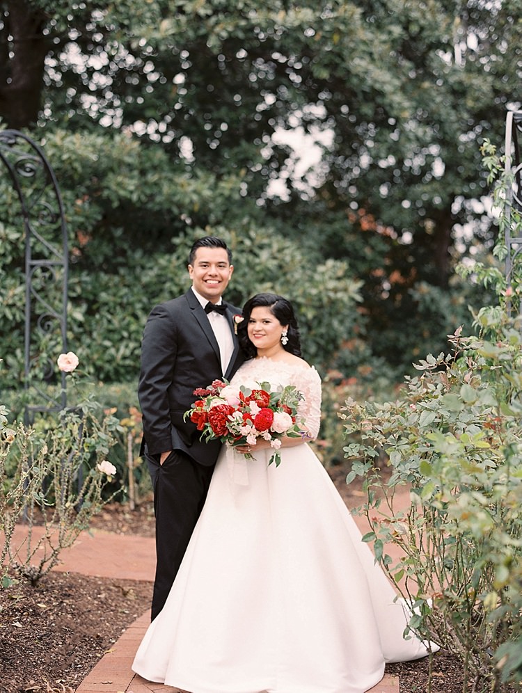 Bride Groom Garden Bowtie Lace Dress Off Shoulder Sleeves Bouquet Red Pink Peonies Roses Greenery Modern Romantic Winter Wedding Texas http://www.albarosephotography.com/