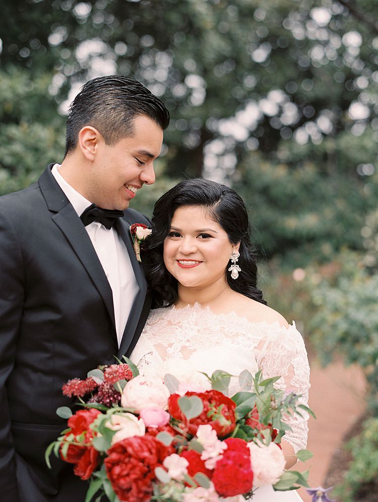 Bride Groom Garden Bowtie Lace Dress Off Shoulder Sleeves Bouquet Red Pink Peonies Roses Greenery Modern Romantic Winter Wedding Texas http://www.albarosephotography.com/