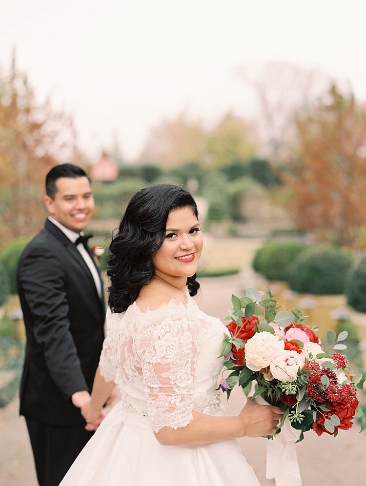 Bride Groom Garden Bowtie Lace Dress Off Shoulder Sleeves Bouquet Red Pink Peonies Roses Greenery Modern Romantic Winter Wedding Texas http://www.albarosephotography.com/