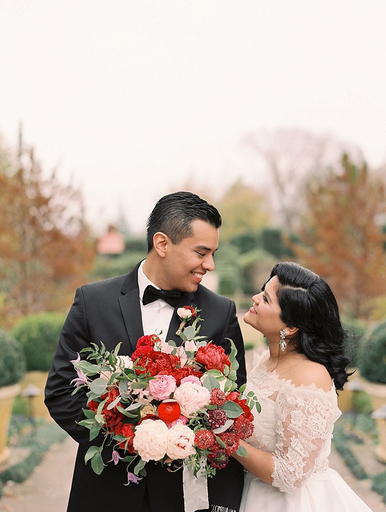 Bride Groom Garden Bowtie Lace Dress Off Shoulder Sleeves Bouquet Red Pink Peonies Roses Greenery Modern Romantic Winter Wedding Texas http://www.albarosephotography.com/