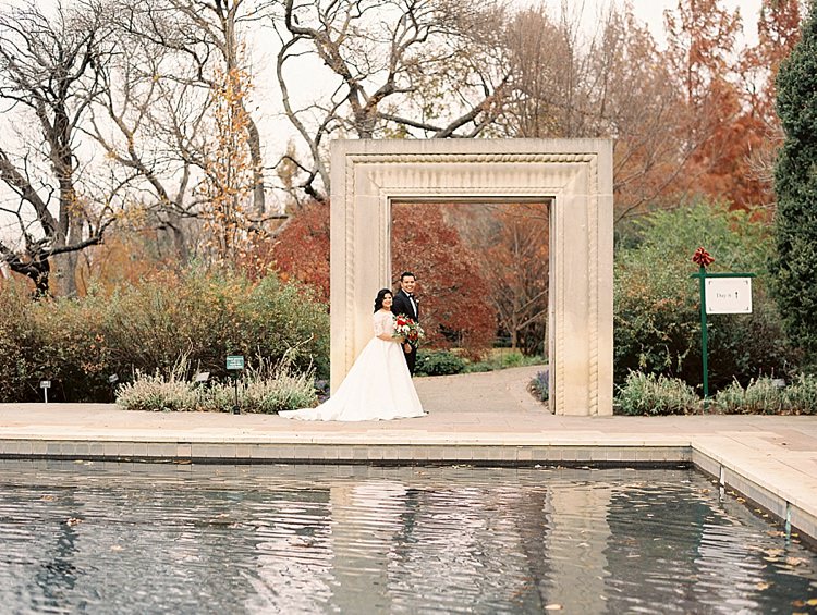 Bride Groom Garden Bowtie Lace Dress Off Shoulder Sleeves Bouquet Red Pink Peonies Roses Greenery Lake Modern Romantic Winter Wedding Texas http://www.albarosephotography.com/