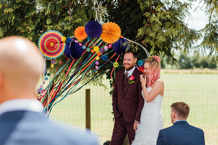 Ceremony Arch Backdrop Ribbons Pinwheels Pom Poms Alternative Colourful Outdoor Humanist Village Hall Wedding http://www.chebirchhayesphotography.com/