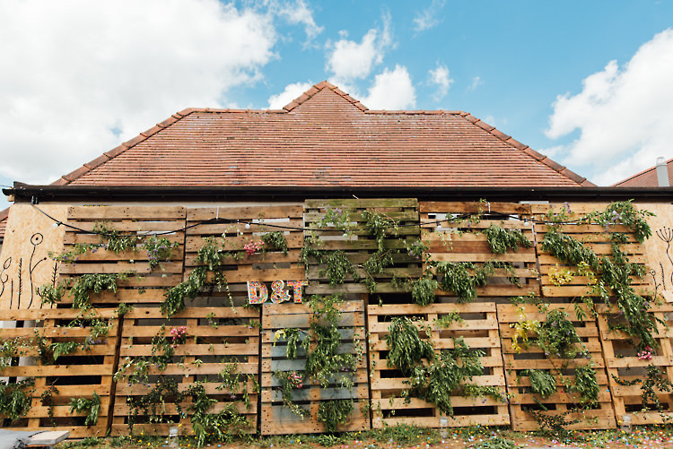 Foliage Greenery Wall Wooden Pallet Festoon Lights Alternative Colourful Outdoor Humanist Village Hall Wedding http://www.chebirchhayesphotography.com/
