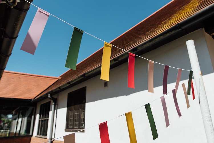 Ticker Tape Bunting Alternative Colourful Outdoor Humanist Village Hall Wedding http://www.chebirchhayesphotography.com/