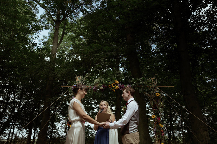 Vows Bamboo Ceremony Structure Floral Flowers Foliage Bespoke Bride Waisted Belt Tweed Groom Waistcoat Chinos Magical Woodland Clearing Colourful Tipis Wedding https://www.lukebellphotography.co.uk/