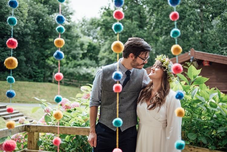 Bride Bridal Flower Crown Wildflower Meadow long Sleeve Silk Dress 70s Grey Tweed Suit Navy Trousers Gingham Shirt Blue Pom Pom Curtain Trailing Multicolour Adventurous Festival Bohemian Wedding https://libertypearlphotography.com/