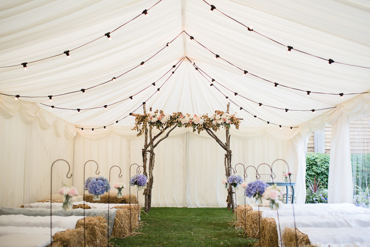 Marquee Ceremony Backdrop Arbour Flowers Floral Pastel Shepherds Crook Paper Pom Pom Festoon Lighting Personal Homegrown Country Farm Wedding https://www.emmahare.com/