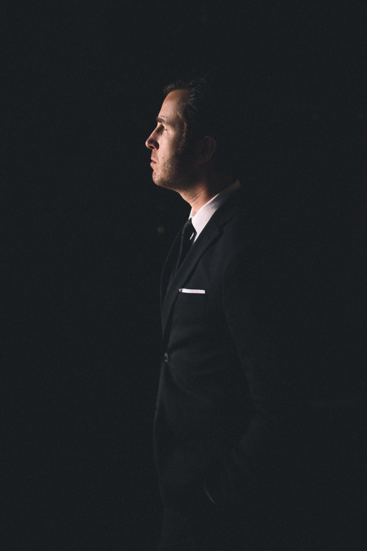 Dark Moody Black Suit Groom Light Silhouette | Edgy Emerald City Wedding Ideas http://www.yvonnegollphotography.com/