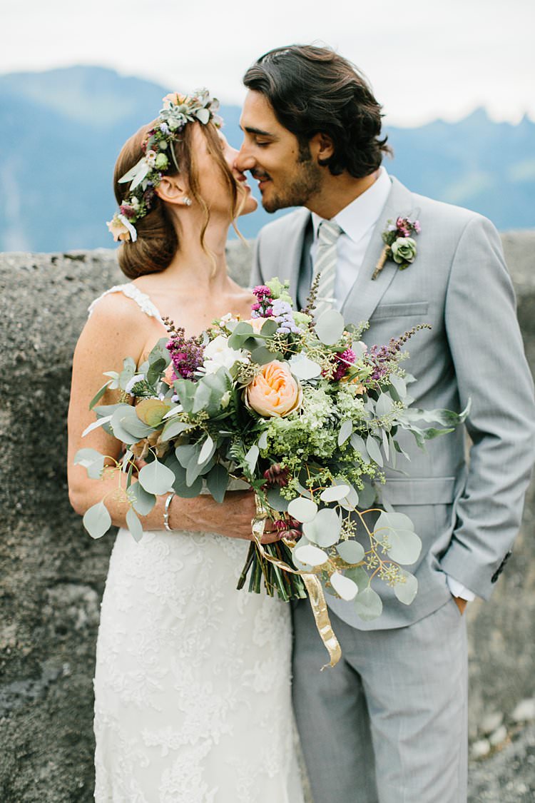 Beautiful Destination Mountains Summer Kiss Bride Groom Wild Bouquet Grey Suit | Romantic Castle Switzerland Wedding http://kbalzerphotography.com/