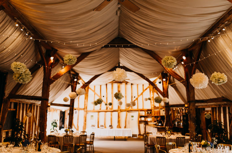 Informal Decor Paper Pompom Fairy Lights Draping Wooden Beams | Rustic Relaxed Cornflower Blue Barn Wedding http://www.peterhugophotography.com/