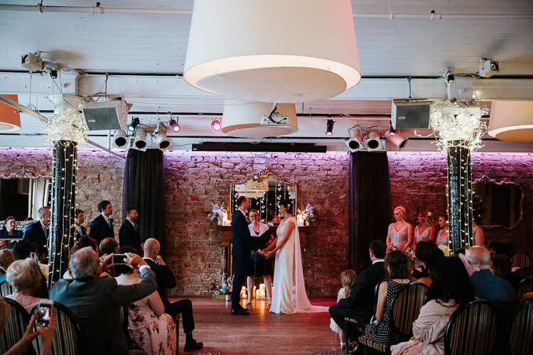 Urban Decor Ceremony Aisle Hanging Floral Curtain Bride Groom Cape Dress | Glitter Dinosaurs City Wedding https://struvephotography.co.uk/
