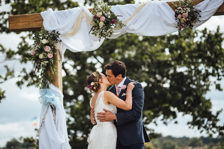 Wooden Arch Backdrop Ceremony Fabric Drapes Flowers Festival Bohemian Glamping Wedding https://theshannons.photography/