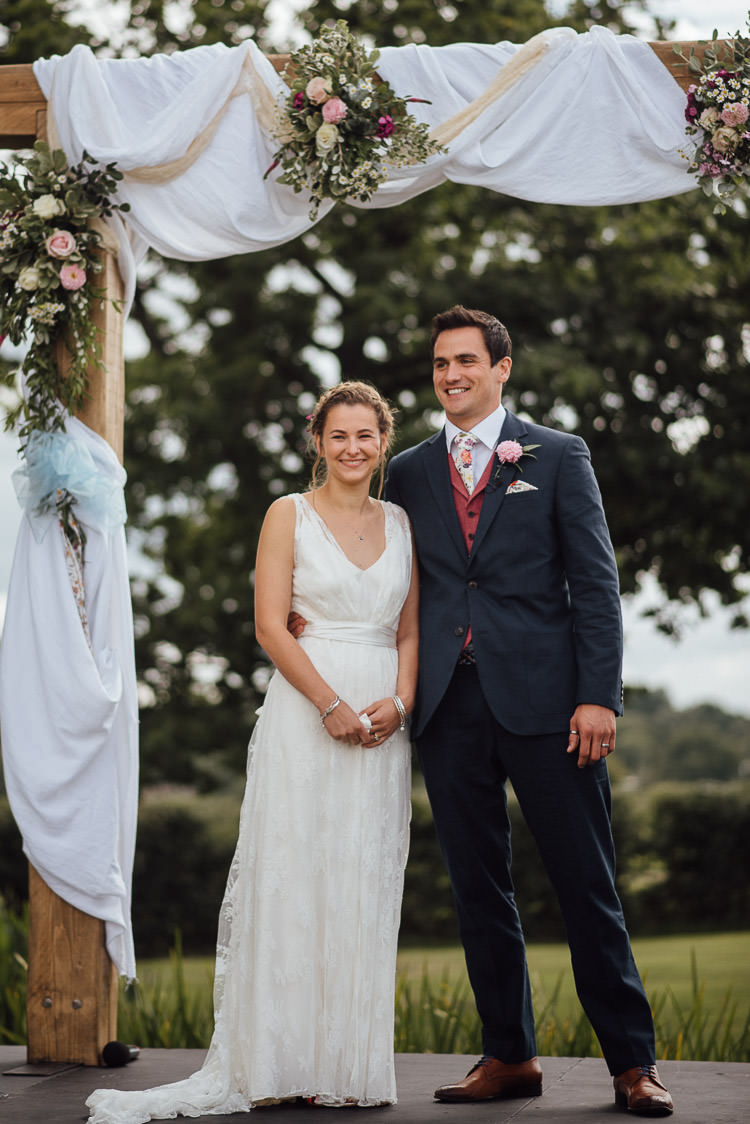 Wooden Arch Backdrop Ceremony Fabric Drapes Flowers Festival Bohemian Glamping Wedding https://theshannons.photography/