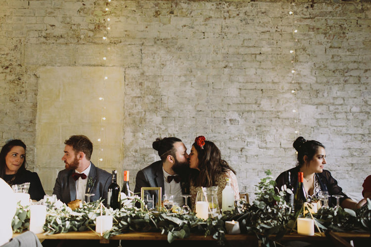 Bride Bridal Dress Gown Lace Long Sleeve Sweetheart Red Burgundy Rose Flower Crown Grey Tweed Groom Bow Tie Top Table Greenery Garland Candles Alternative London Warehouse Wedding https://www.lukehayden.co.uk/