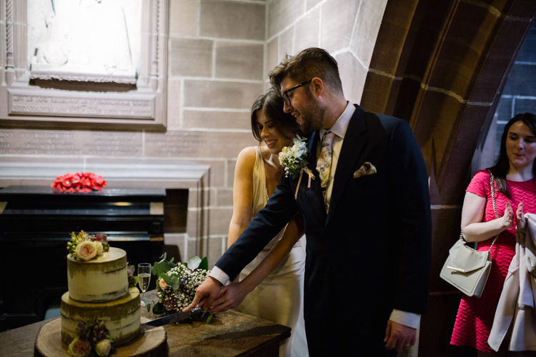 Bride Bridal Gown Dress Silk Bias V Neck Lace Insert Groom Pocket Square Navy Suit Cake Cutting Buttercream Tiered Wood Slice Floral Flowers Playful Metallic Zoo Winter Wedding https://www.jennbrookesphotographer.com/
