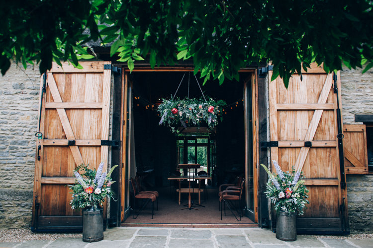Barn Ceremony Door Flowers Hanging Hoop Churns Flowery Bohemian Secret Garden Wedding https://caseyavenue.co.uk/